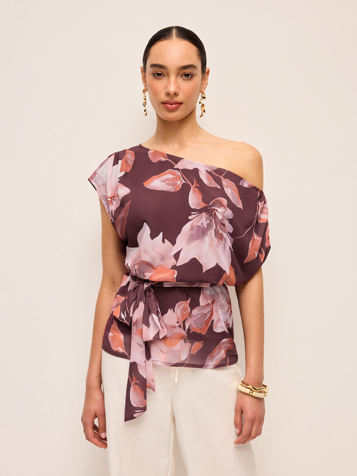 Blus med blommigt skärp och en axel