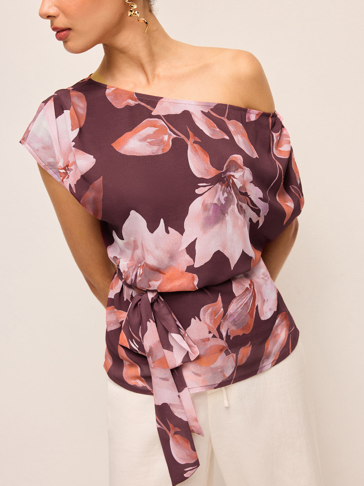 Blus med blommigt skärp och en axel